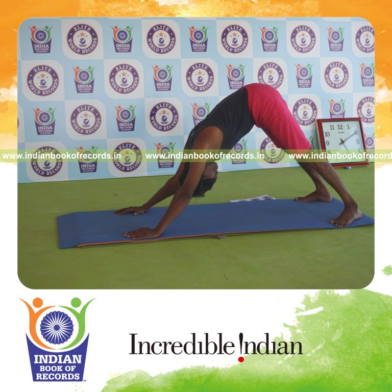individual holding adho mukha svanasana yoga pose blindfolded for record in Indian Book of Records