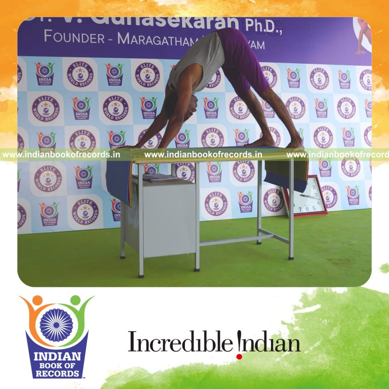 individual holding adho mukha svanasana yoga pose on a table for record in Indian Book of Records