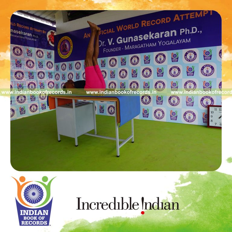 individual holding ardha halasana yoga pose on a table for record in Indian Book of Records