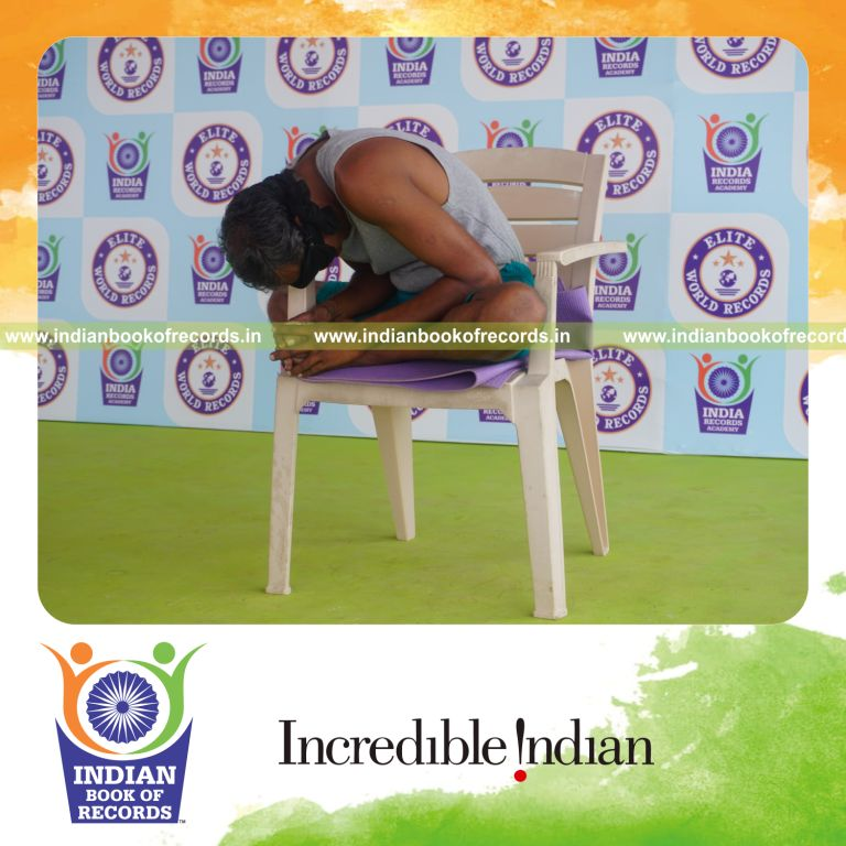 individual holding baddha konasana yoga pose blindfolded on a chair for record in Indian Book of Records