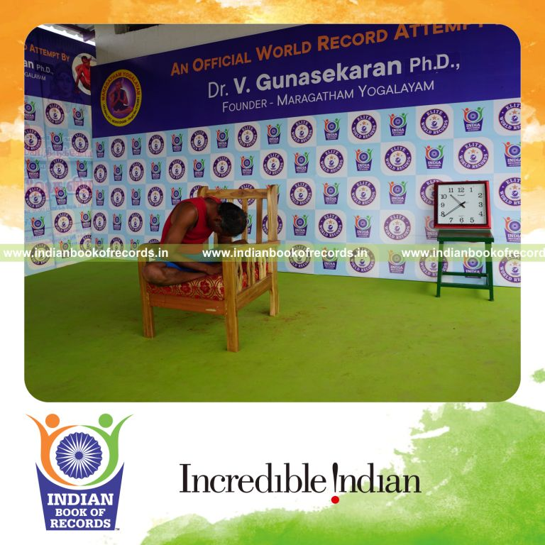 individual holding baddha konasana yoga pose on a chair for record in Indian Book of Records