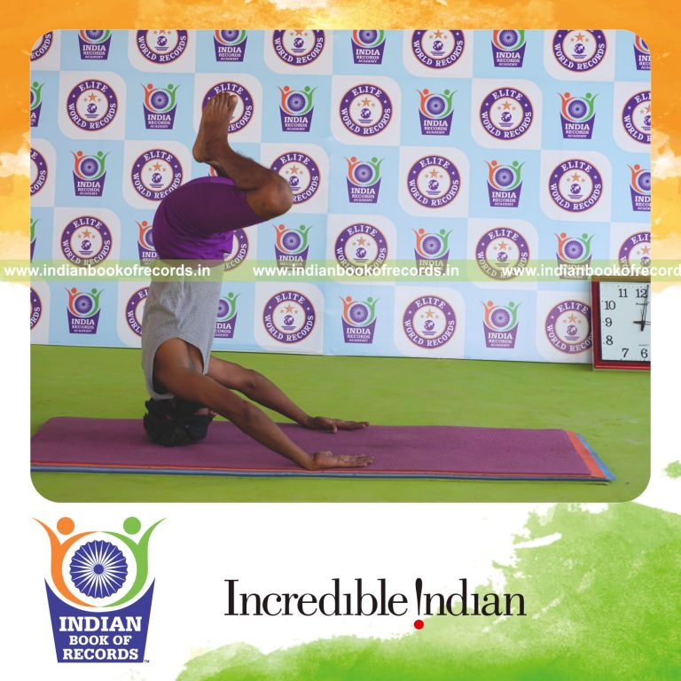 individual holding baddha mukta sirsasana yoga pose blindfolded for record in Indian Book of Records