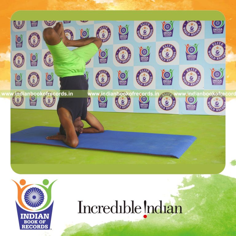 an individual holding baddha salamba sirsasana yoga pose blindfolded for the longest duration with stability and control for a record in Indian Book of Records