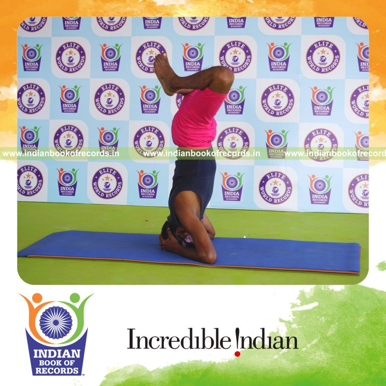 an individual holding baddha sirasasana yoga pose blindfolded for the longest duration with strength and stability for a record in Indian Book of Records