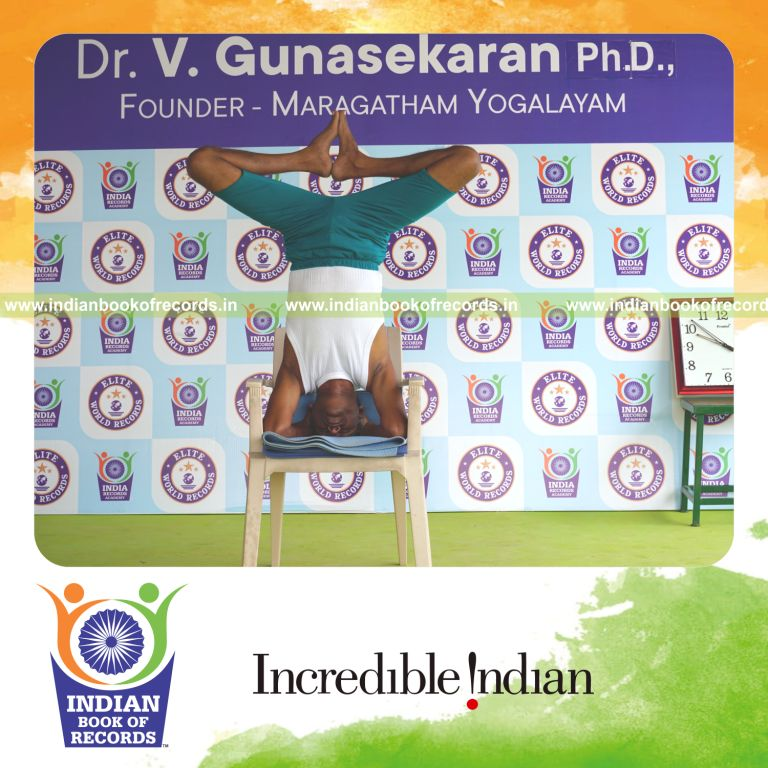individual holding baddha sirasasana yoga pose on a chair for record in Indian Book of Records