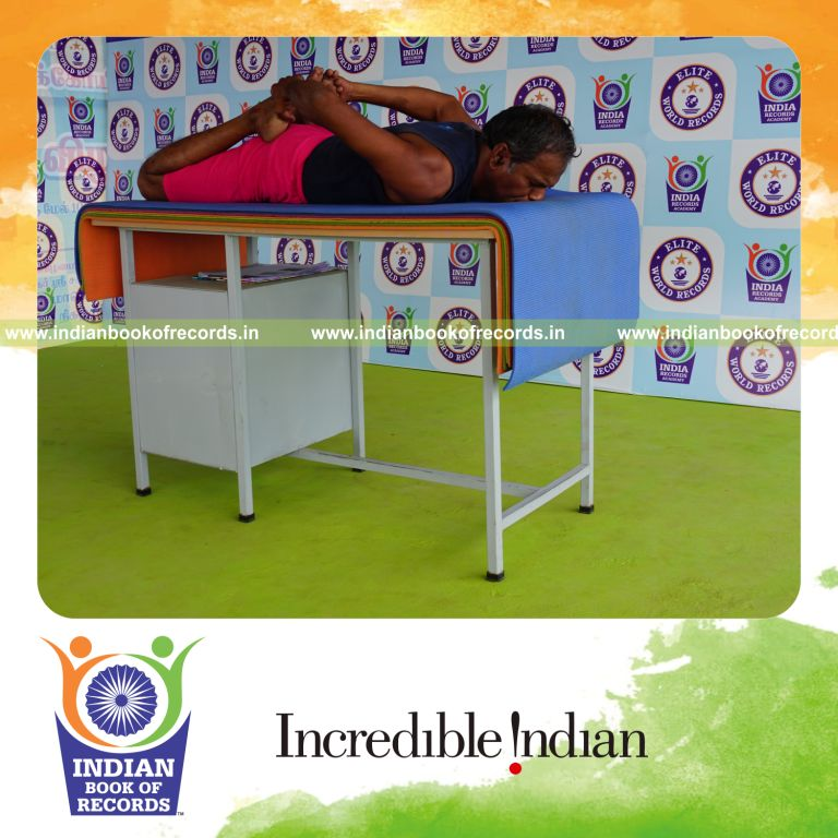 individual holding bhekasana yoga pose on a table for record in Indian Book of Records