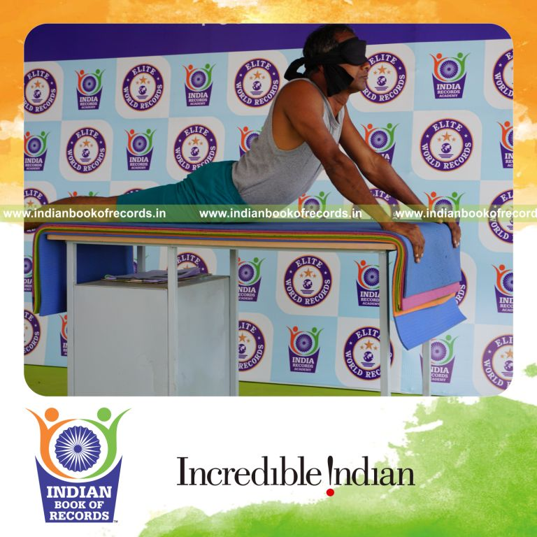 individual holding bhujangasana yoga pose blindfolded on a table for record in Indian Book of Records