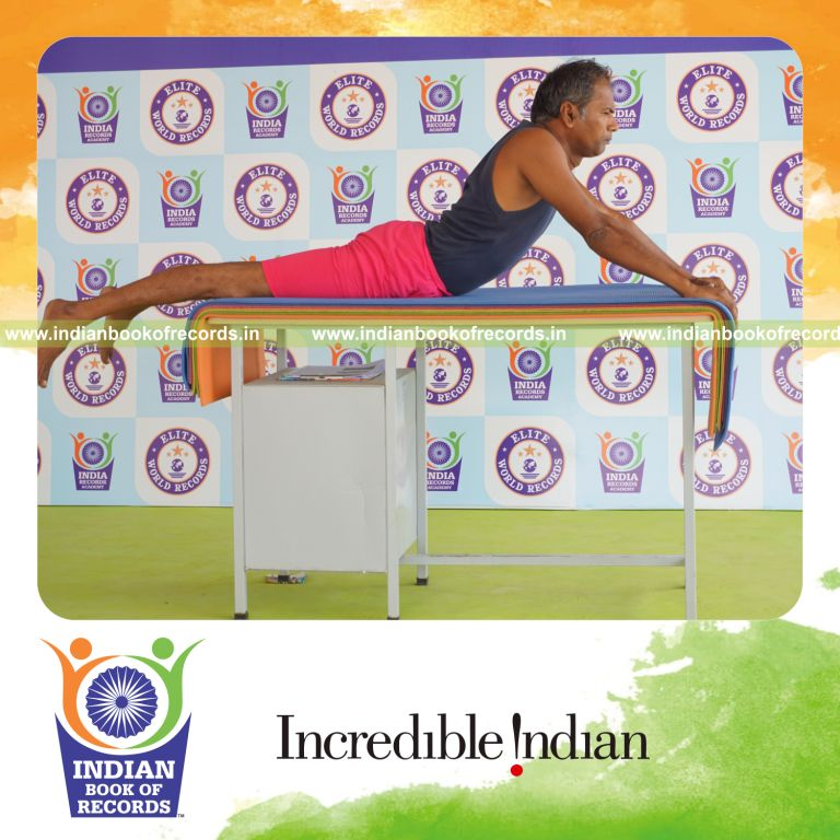 individual holding bhujangasana yoga pose on a table for record in Indian Book of Records