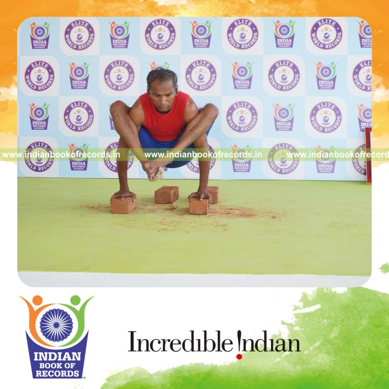 individual holding bhujapidasana yoga pose on bricks for record in Indian Book of Records