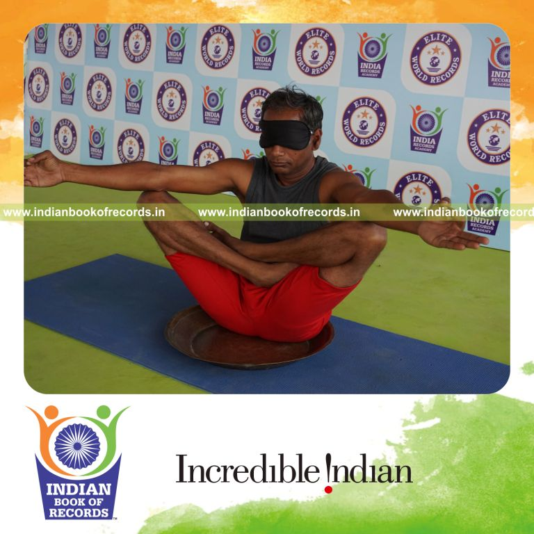 individual holding chinmudra thulangasana yoga pose blindfolded on a brass plate for record in Indian Book of Records