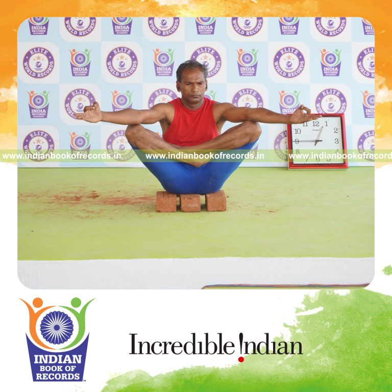 individual holding chinmudra thulangasana yoga pose on bricks for record in Indian Book of Records