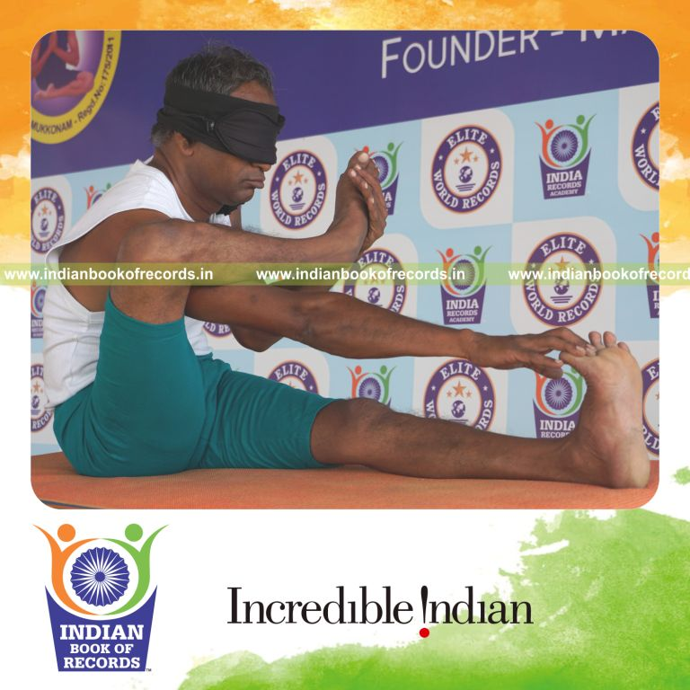 an individual holding daksina akarna dhanurasana yoga pose blindfolded on a table continuously for the longest duration with balance and control for a record in Indian Book of Records