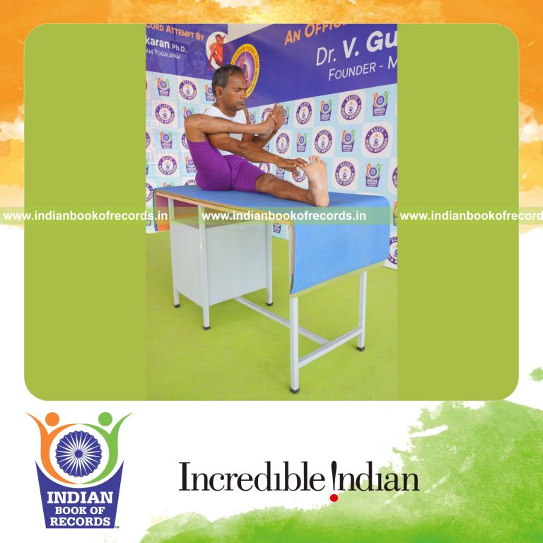 individual holding daksina akarna dhanurasana yoga pose on a table for record in Indian Book of Records