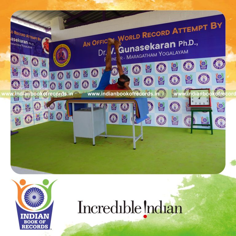 individual holding daksina anandasana yoga pose blindfolded on a table for record in Indian Book of Records