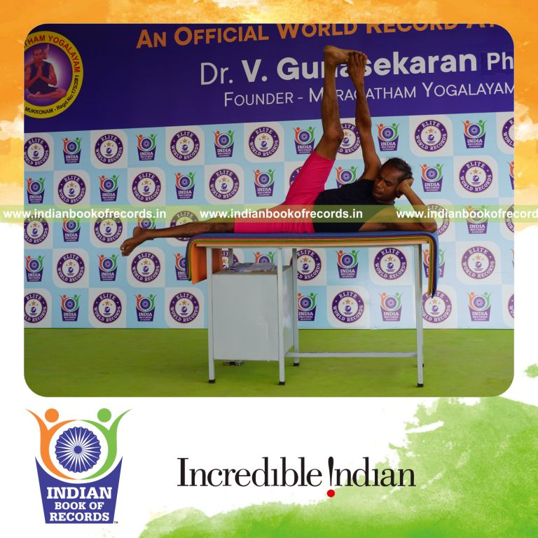 individual holding daksina anandasana yoga pose on a table for record in Indian Book of Records