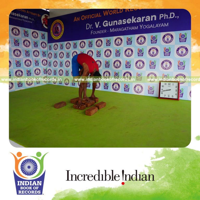 individual holding daksina ardha baddha padmottasana yoga pose on bricks for record in Indian Book of Records