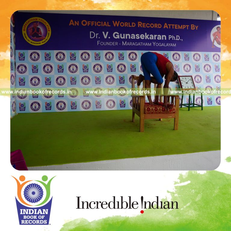 individual holding daksina ardha baddha padmottasana yoga pose on a chair for record in Indian Book of Records
