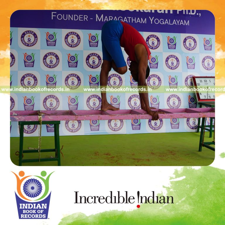 individual holding daksina ardha baddha padmottasana yoga pose on a ladder for record in Indian Book of Records