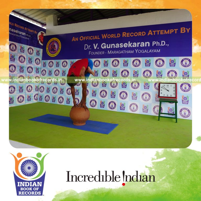 individual holding daksina ardha baddha padmottasana yoga pose on a pot for record in Indian Book of Records