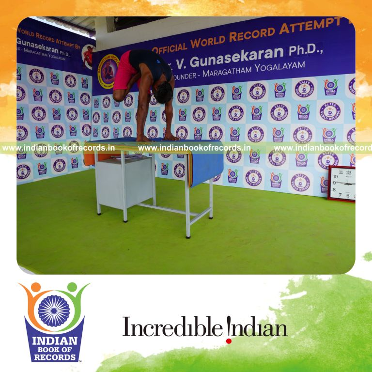 individual holding daksina ardha baddha padmottasana yoga pose on a table for record in Indian Book of Records