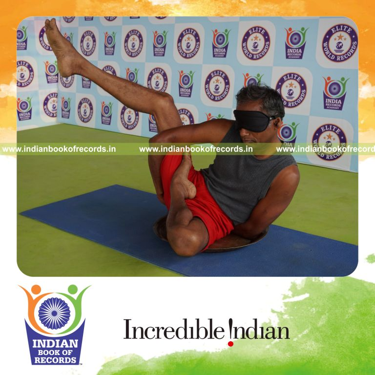 individual holding daksina ardha baddha parsva krounchasana yoga pose blindfolded on a brass plate for record in Indian Book of Records