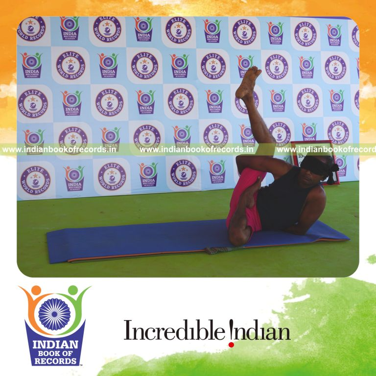 an individual holding daksina ardha baddha parsva krounchasana yoga pose blindfolded for the longest duration with flexibility and control for a record in Indian Book of Records