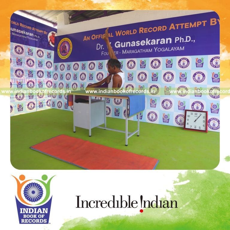 individual holding daksina ardha baddha parsva krounchasana yoga pose on a table for record in Indian Book of Records