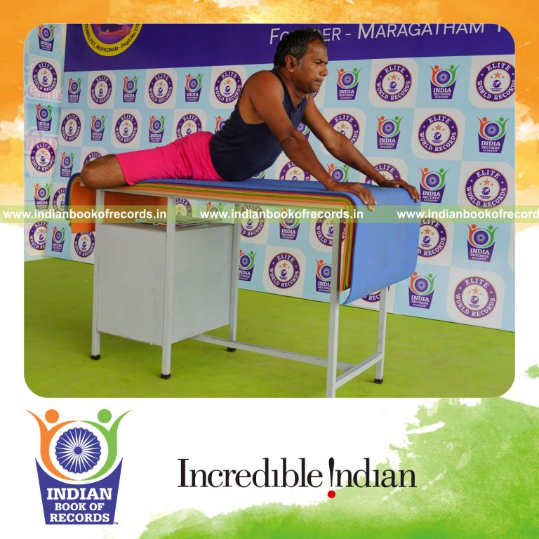 individual holding daksina ardha bhujangasana yoga pose on a table for record in Indian Book of Records