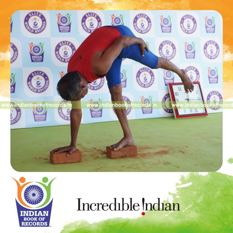 individual holding daksina ardha chandrasana yoga pose on bricks for record in Indian Book of Records