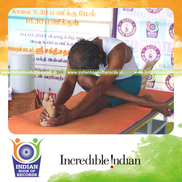 an individual holding daksina ardha janu sirsasana yoga pose blindfolded on a table continuously for the longest duration with balance and control for a record in Indian Book of Records