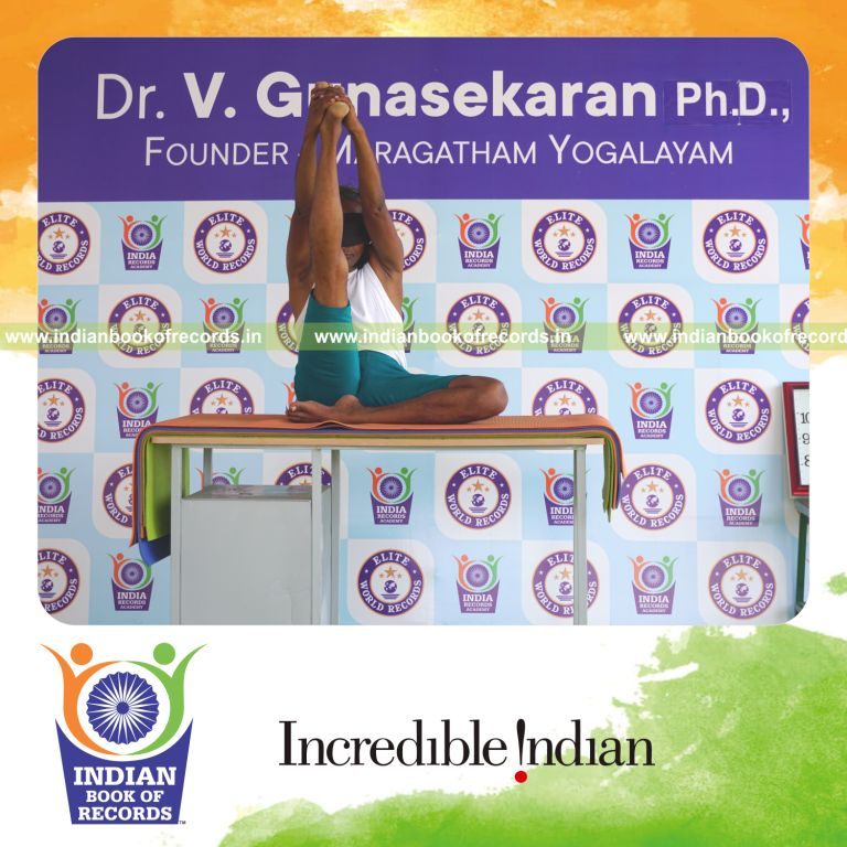 an individual holding daksina ardha krounchasana yoga pose blindfolded on a table continuously for the longest duration with balance and control for a record in Indian Book of Records
