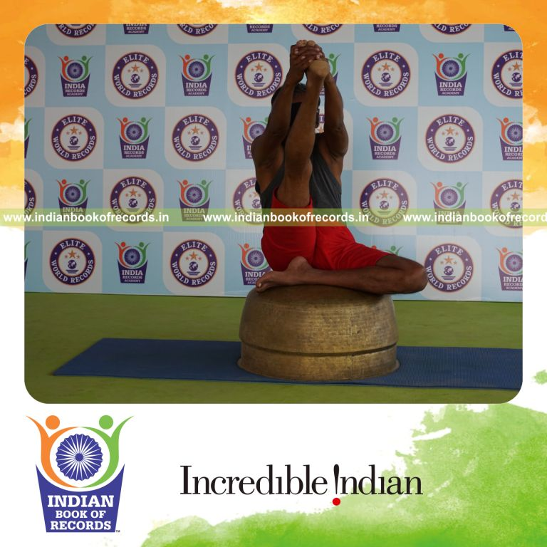 individual holding daksina ardha krounchasana yoga pose blindfolded on a vessel for record in Indian Book of Records