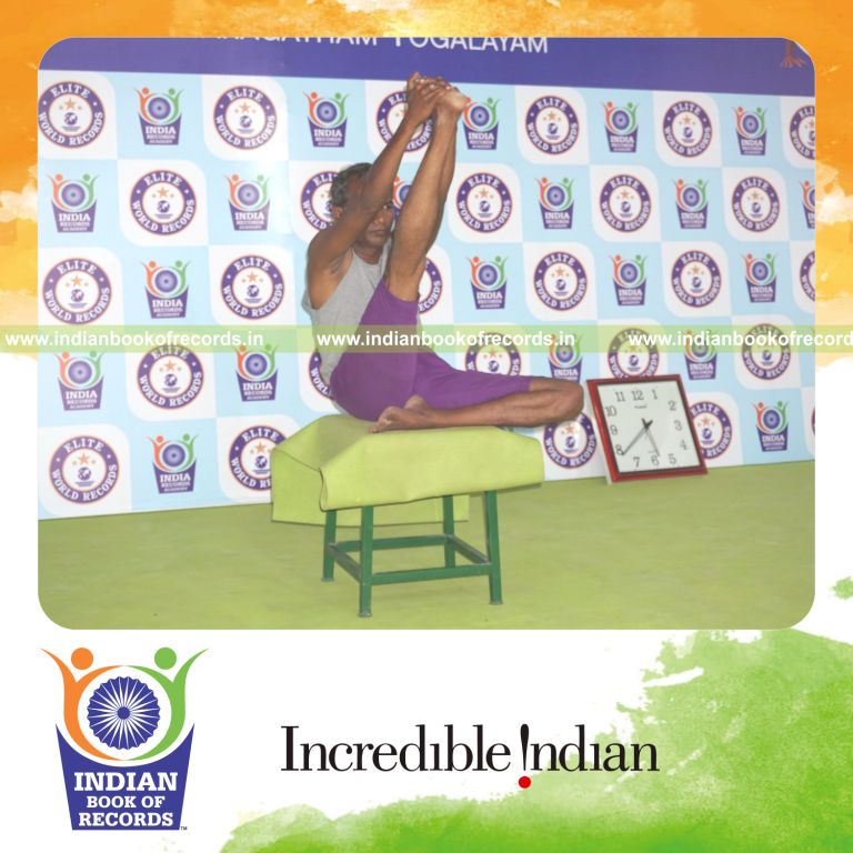 individual holding daksina ardha krounchasana yoga pose on a stool for record in Indian Book of Records