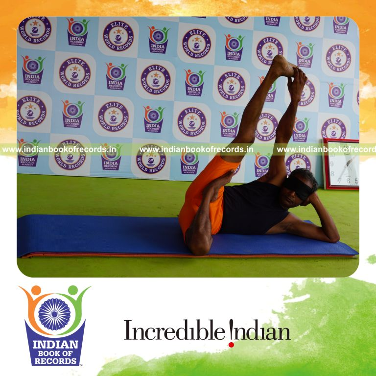 individual holding daksina ardha padma anantasana yoga pose blindfolded for record in Indian Book of Records