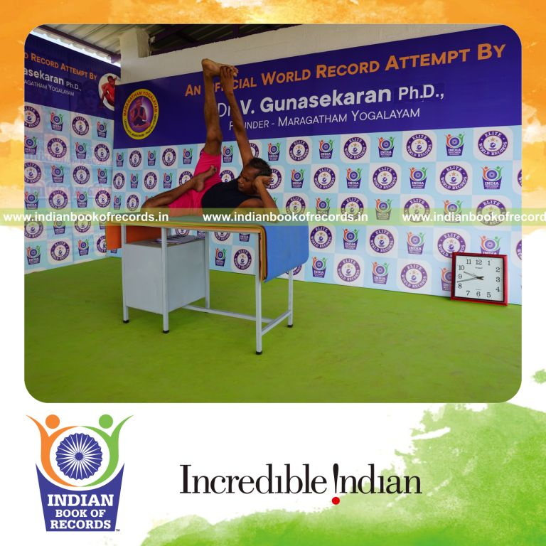 individual holding daksina ardha padma anantasana yoga pose on a table for record in Indian Book of Records