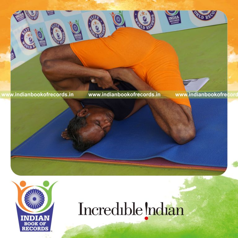 individual holding daksina ardha padma astavakrasana yoga pose for record in Indian Book of Records