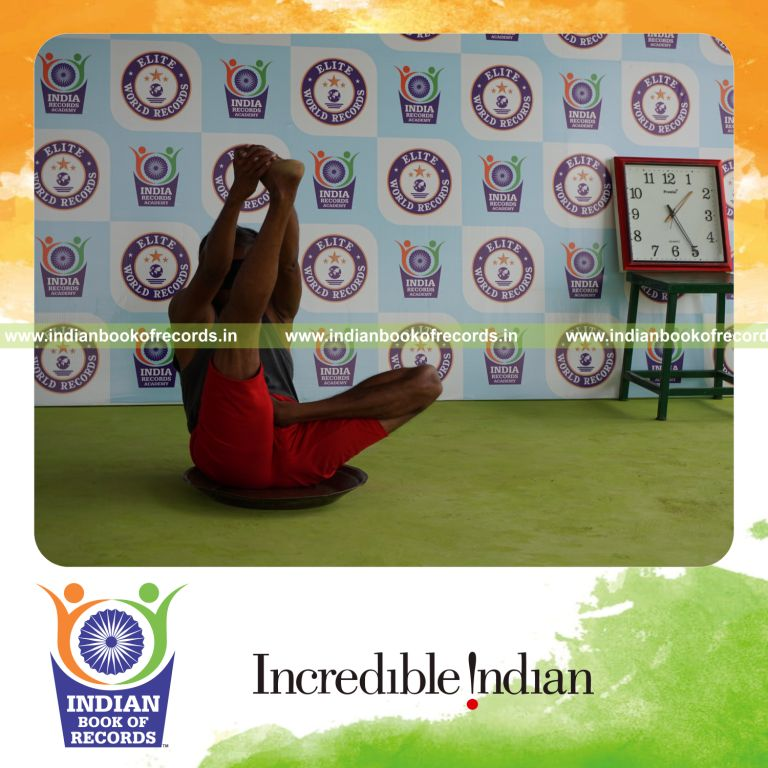 individual holding daksina ardha padma krounchasana yoga pose blindfolded on a brass plate for record in Indian Book of Records