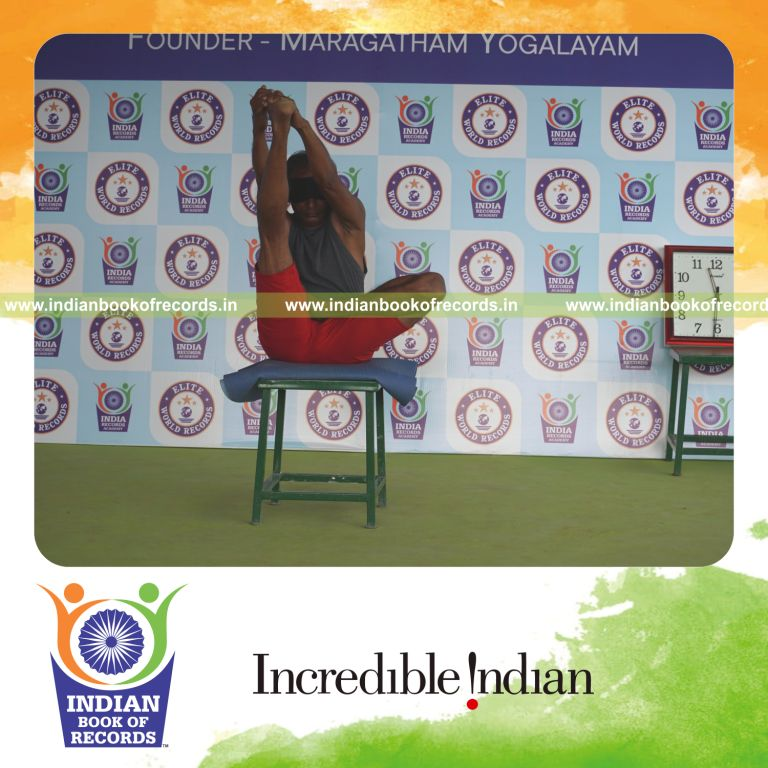 individual holding daksina ardha padma krounchasana yoga pose blindfolded on a stool for record in Indian Book of Records