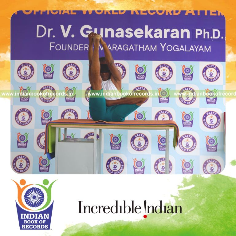 an individual holding daksina ardha padma krounchasana yoga pose blindfolded on a table continuously for the longest duration with stability and control for a record in Indian Book of Records