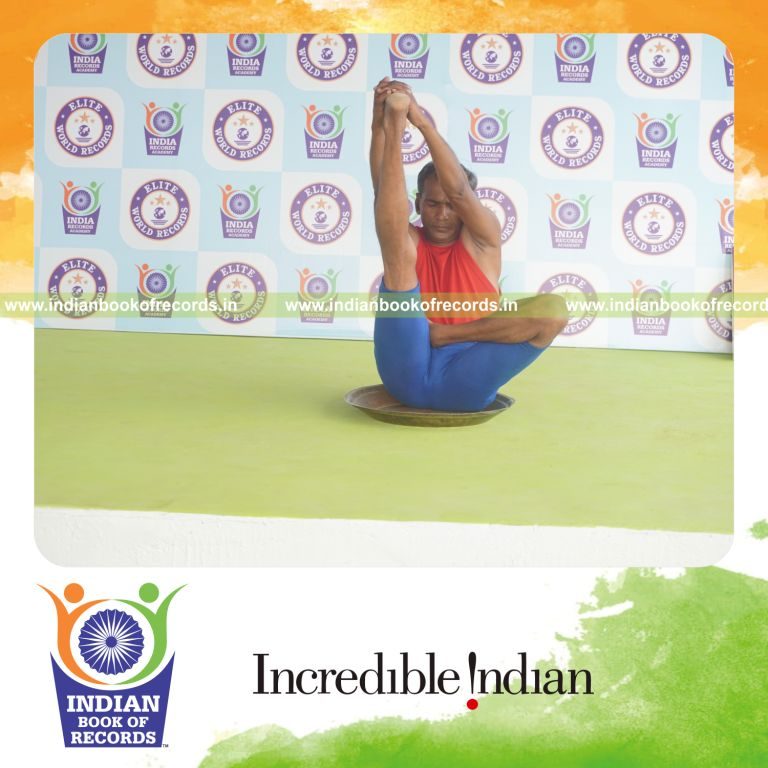 individual holding daksina ardha padma krounchasana yoga pose on a brass plate for record in Indian Book of Records