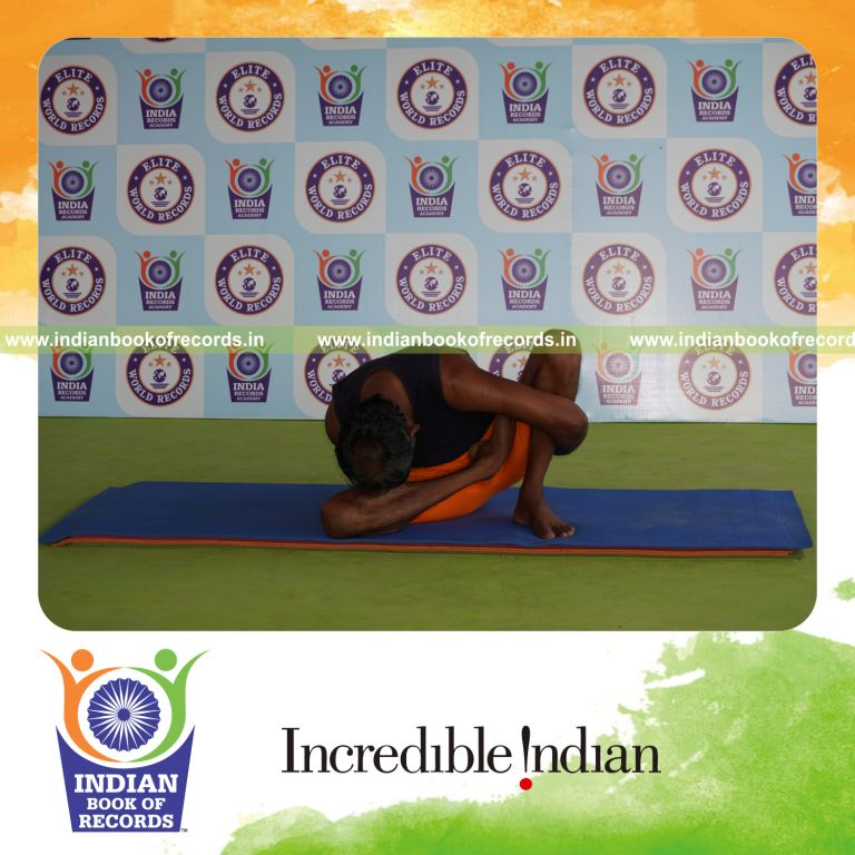 individual holding daksina ardha padma marichyasana yoga pose blindfolded for record in Indian Book of Records