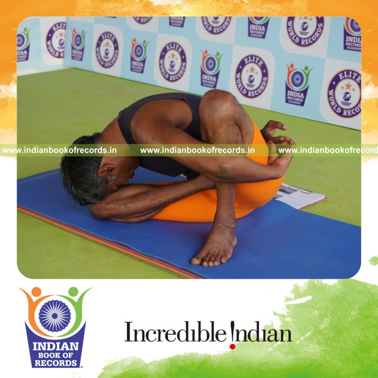 individual holding daksina ardha padma marichyasana yoga pose for record in Indian Book of Records