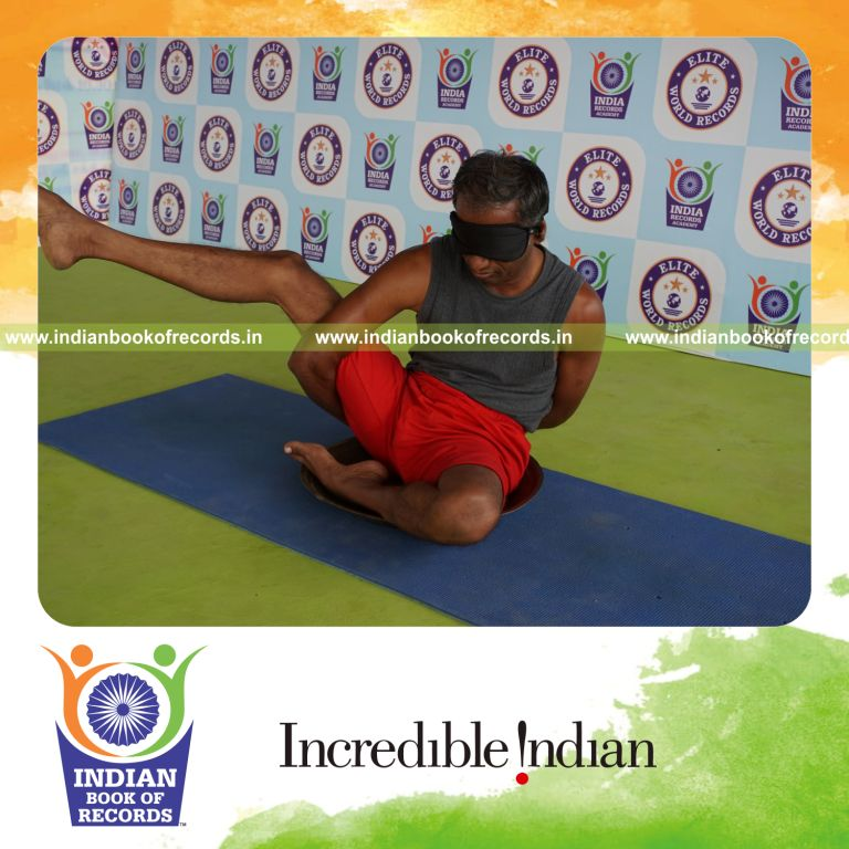 individual holding daksina ardha parsva krounchasana yoga pose blindfolded on a brass plate for record in Indian Book of Records