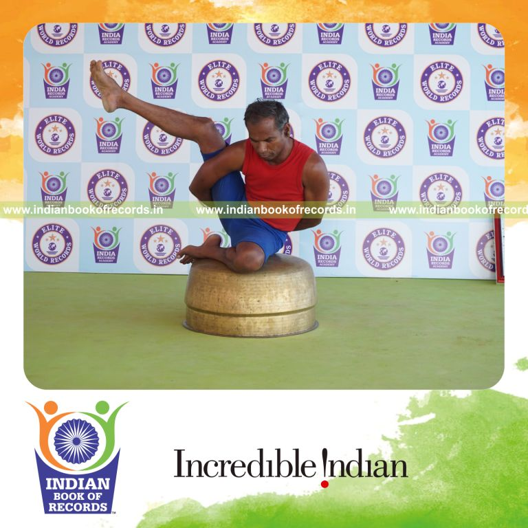 individual holding daksina ardha parsva krounchasana yoga pose on a vessel for record in Indian Book of Records