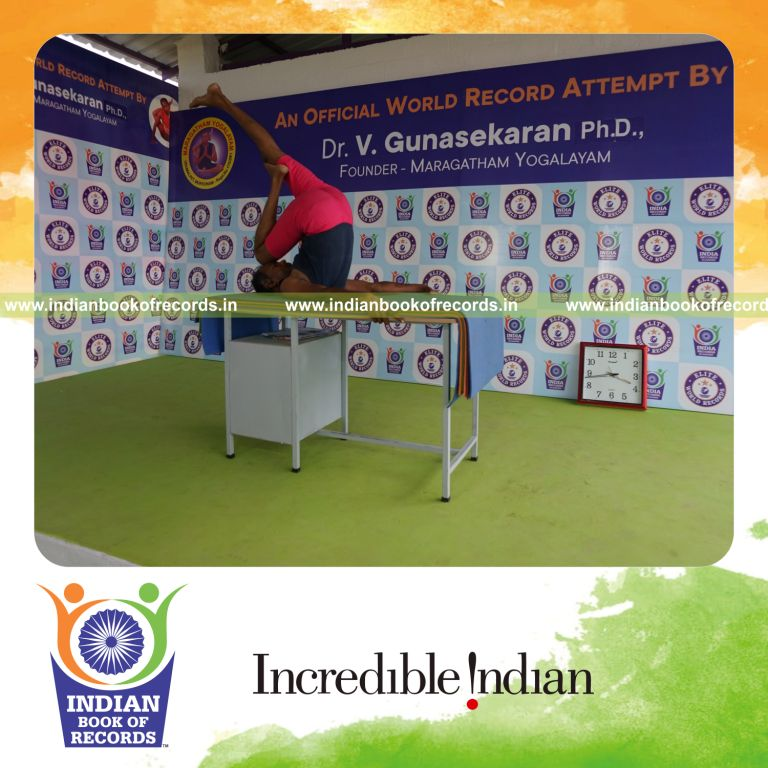 individual holding daksina ardha salamba sarvangasana yoga pose on a table for record in Indian Book of Records