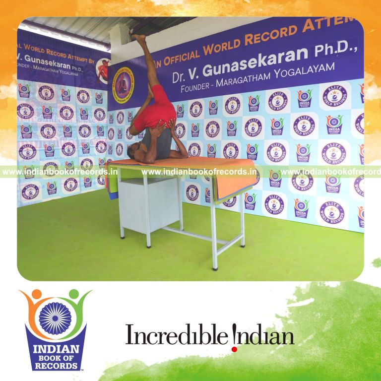 individual holding daksina ardha sarvangasana yoga pose on a table for record in Indian Book of Records