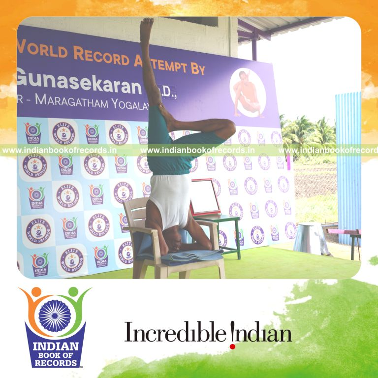 individual holding daksina ardha sirsasana yoga pose on a chair for record in Indian Book of Records