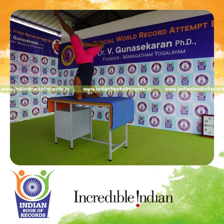 individual holding daksina ardha sirsasana yoga pose on a table for record in Indian Book of Records