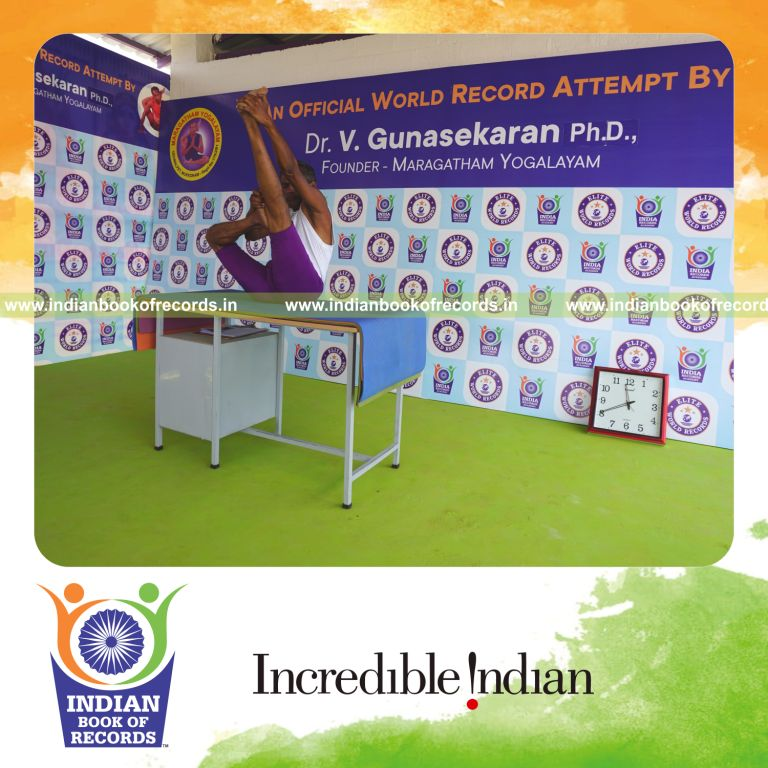 individual holding daksina ardha urdhva mukha paschimottanasana yoga pose on a table for record in Indian Book of Records