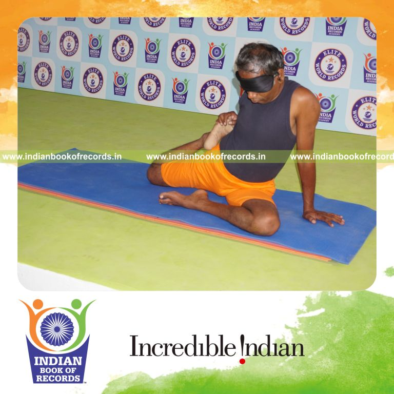 individual holding daksina ardha vamadevasana yoga pose blindfolded for record in Indian Book of Records